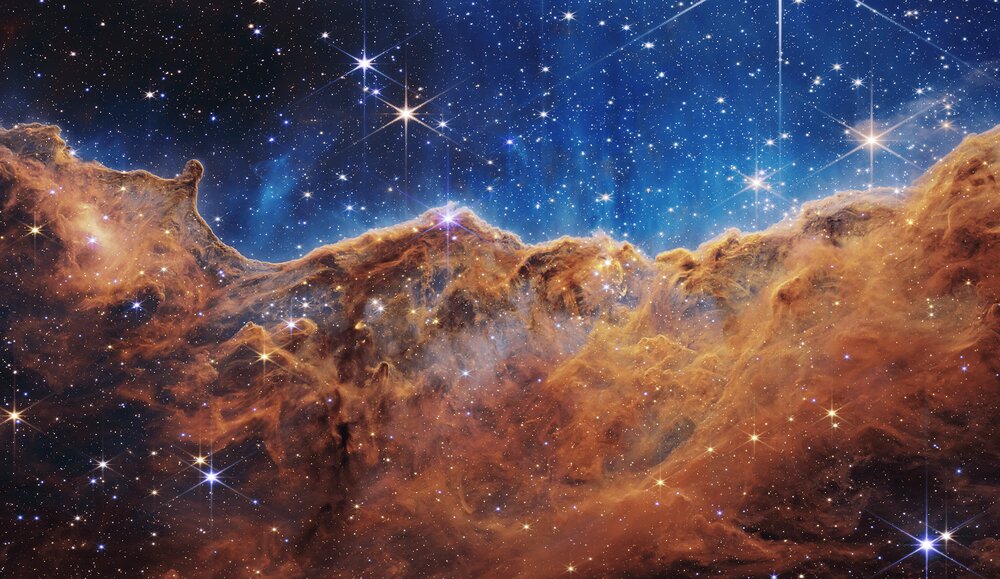 "Los precipicios cósmicos" en la nebulosa de Carina, es un lugar donde se forman estrellas. Esta imagen fue tomada por el sensor NIRCam (son las siglas en inglés de cámara de infrarrojo cercano) del telescopio. Créditos: NASA, ESA, CSA, STScI