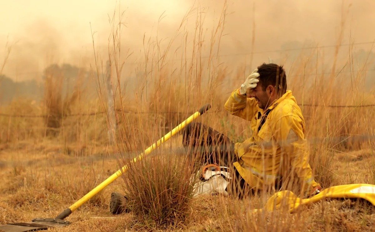 Foto I El "Negro Sanchéz", jefe de bomberos de Caá Catíi, Corrientes, descansa unos segundos en medio del combate al fuego y se toma la cabeza con las manos por la angustia del momento. Sebastián Toba para Reuters.