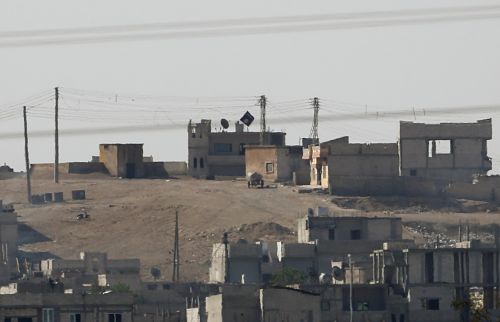 Bandera negra del Estado Islámico en la ciudad sirio kurda de Kobani, vista desde la frontera turca. 9/0/2014. Foto: REUTERS/Umit Bektas