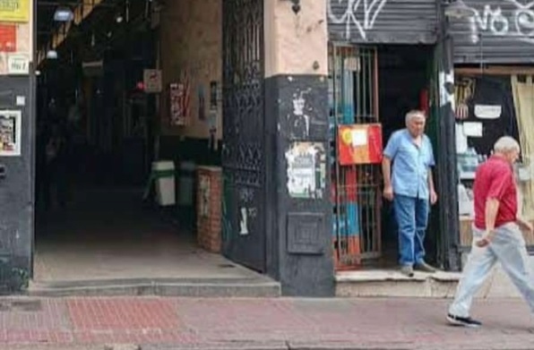 El almacenero Bolívar -de camisa celeste- en la puerta de su comercio.