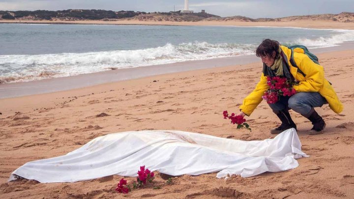 Una mujer coloca flores junto al cadáver de un migrante. Foto de archivo.