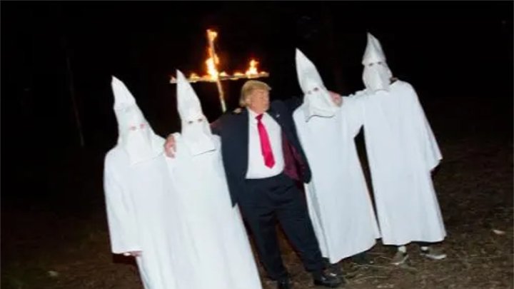 Imagen: Performance artístico parodiando a Trump tomándose fotos con el KKK.