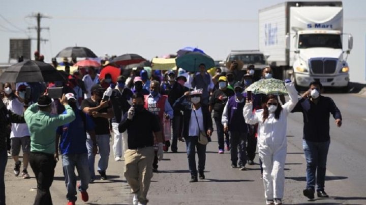 Obreras y obreros de maquilas manifestándose en las frontera con Estados Unidos