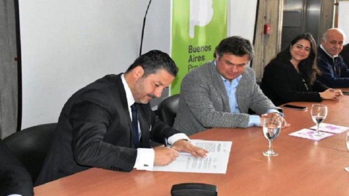 Gustavo Menéndez firmando el precario servicio local de Niñez. Foto: Merlo 24hs