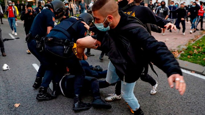 Miembros de la Policía Nacional cargan contra un grupo de manifestantes que protestaban en favor de la Sanidad Pública y contra los confinamientos de clase en Vallecas, Madrid. (EFE | Emilio Naranjo)