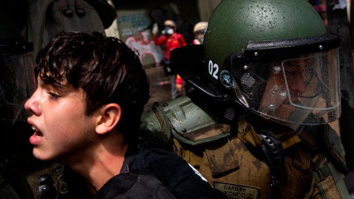 Fuerzas Especiales de Carabineros detienen a manifestantes durante una protesta convocada por organizaciones estudiantiles, quienes protestaron a propósito del inicio del curso escolar 2021, el 1 de marzo, en el centro de Santiago (Chile). Los manifestantes fueron dispersados por carros lanza agua y cargas policiales. EFE/ Alberto Valdés