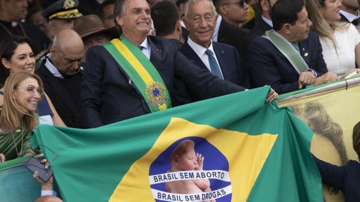 El presidente de Brasil, Jair Bolsonaro, en el desfile de celebración del Bicentenario de la Independencia de Brasil en Brasilia (Brasil), sostiene la bandera brasileña con las inscripciones "Brasil sin aborto" y "Brasil sin drogas" en lugar de "Orden y progreso". EFE/Joedson Alves