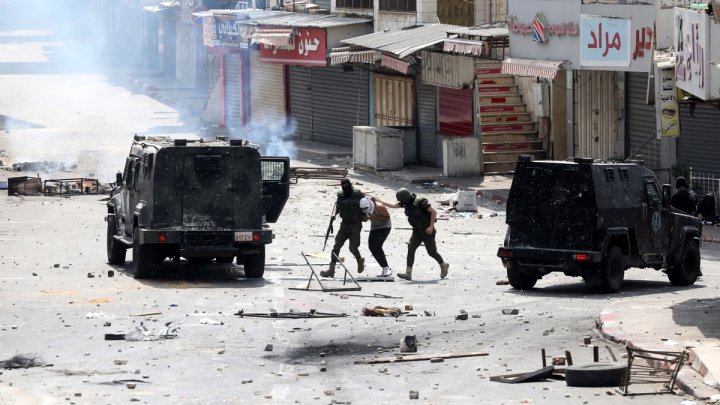 Las fuerzas de seguridad de la Autoridad Palestina detienen a un manifestante palestino en la ciudad cisjordana de Nablus el martes pasado. EFE/ Alaa Badarneh