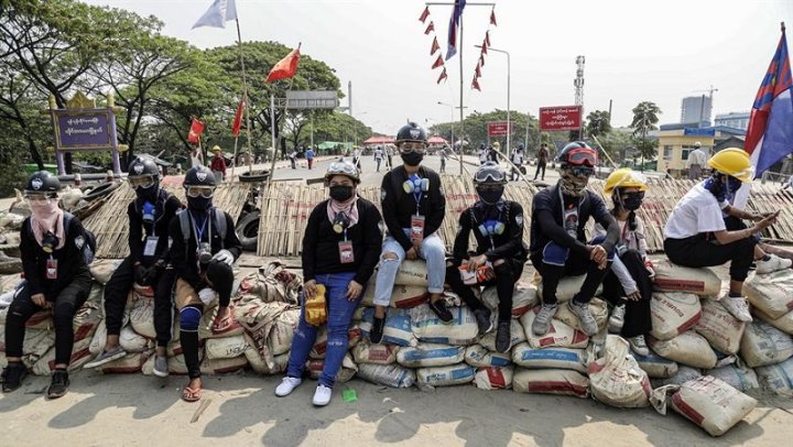 Un grupo de jóvenes espera sentado sobre una barricada en las afueras de Yangon / Efe