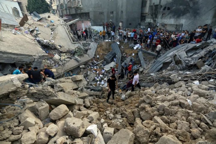 Palestinos revisan los escombros del sitio de la iglesia ortodoxa griega, tras los ataques aéreos israelíes en la ciudad de Gaza, 19/10/23 [Abed Khaled/AP]