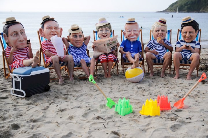 Activistas de Oxfam con cabezas de papel maché que representan a los líderes del G7 actúan durante una protesta en la playa de Swanpool, cerca de Falmouth, durante la cumbre del G7, en Cornualles, Gran Bretaña. EFE/EPA/PHIL NOBLE