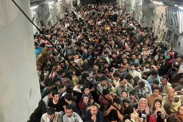 Refugiados afganos en avión estadounidense trasladados a la base militar de Al Udeid, Qatar.