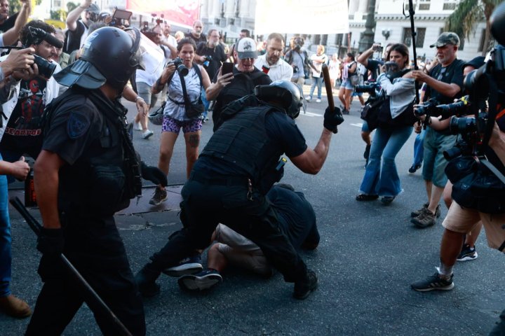 Un policía golpea a un hombre en el suelo durante la protesta de Jubilados frente al Congreso | Foto: Enfoque Rojo